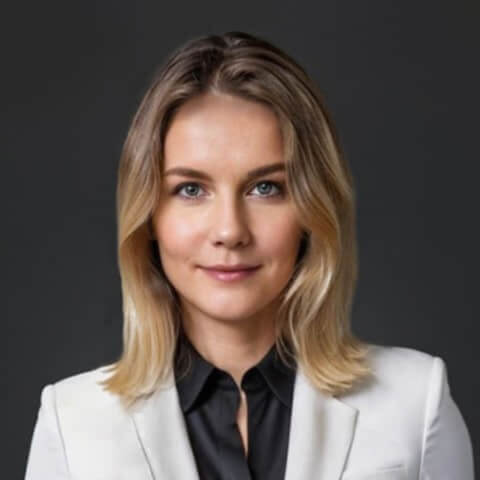 headshot of a woman in professional suit with a black backdrop
