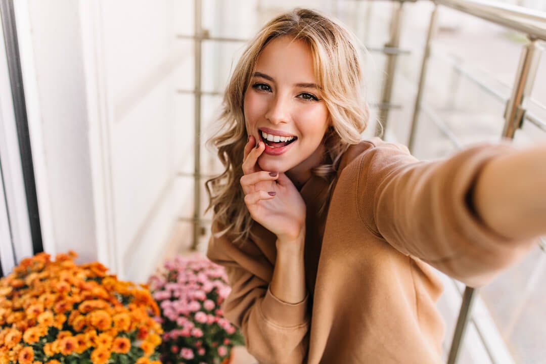 A beautiful girl is taking a selfie with flowers
