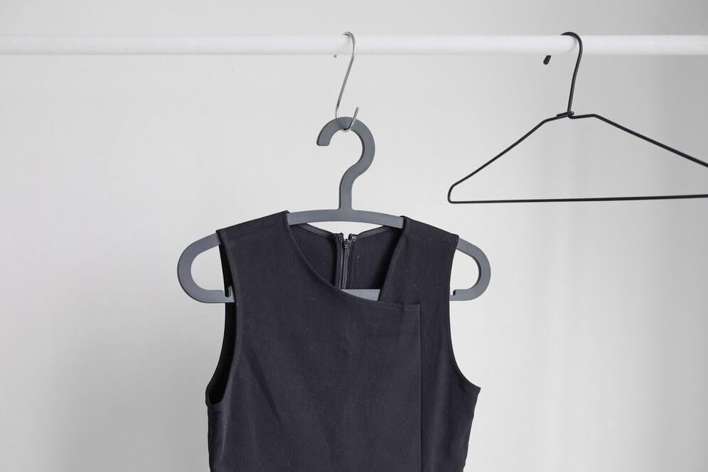 A black vest hanging on a hanger for photo shoots