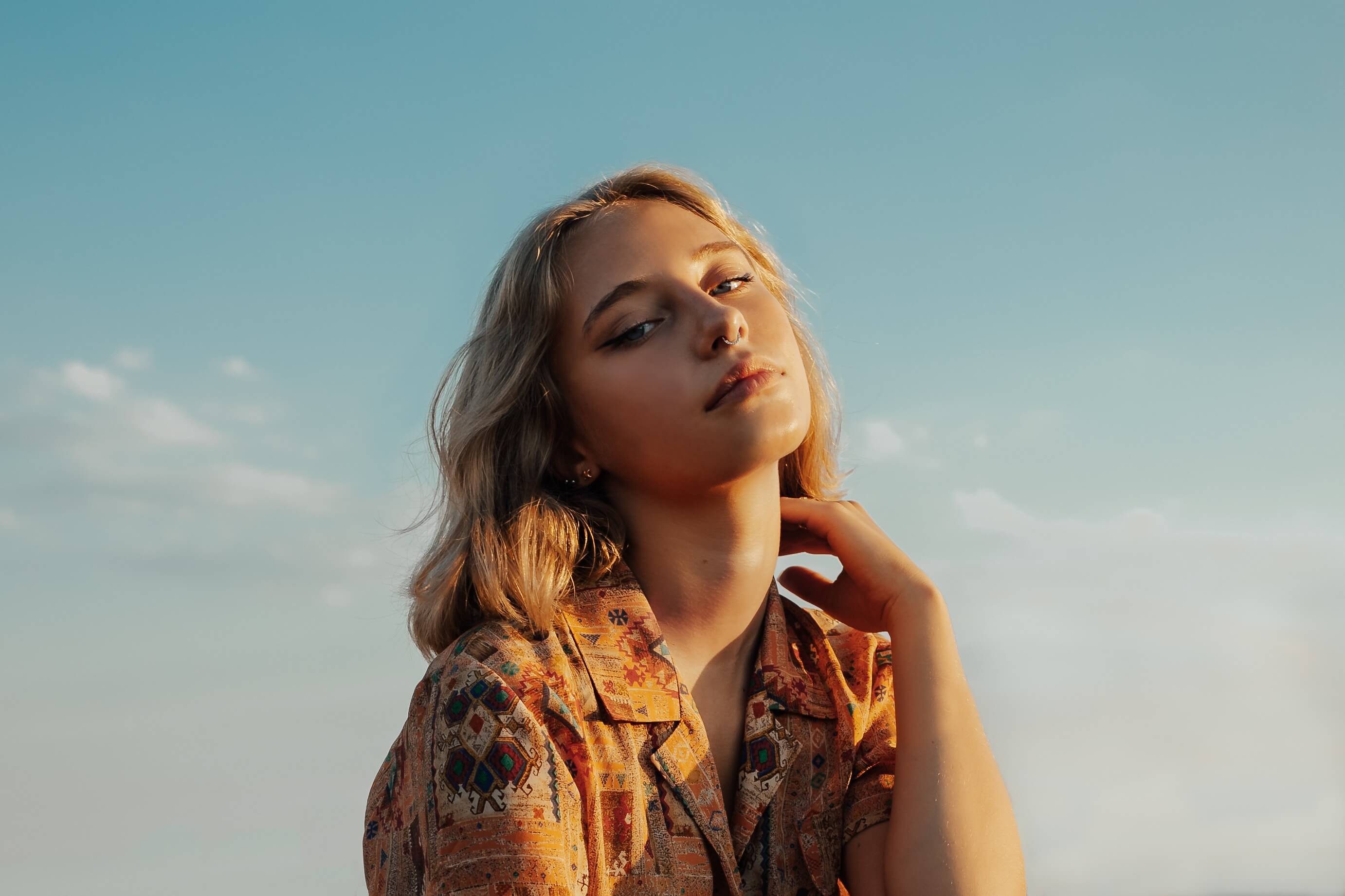 A girl with short blonde hair in a floral shirt