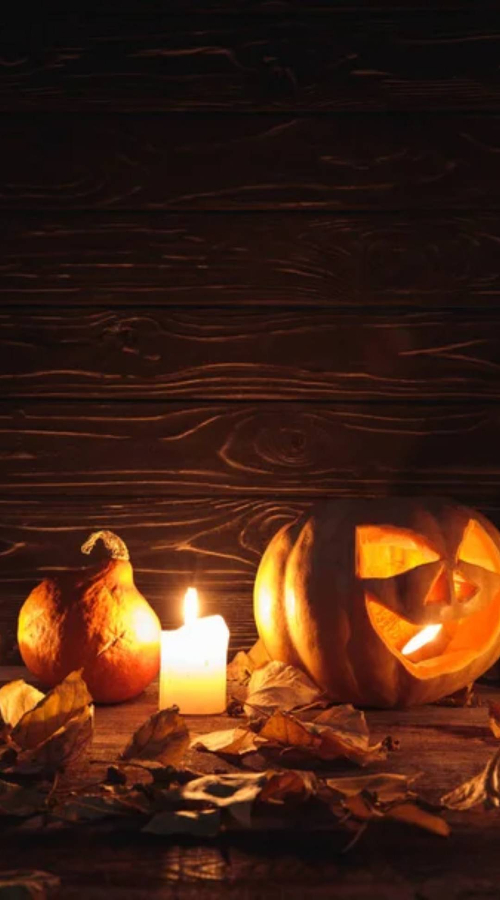 there is a lighted pumpkin on the desk