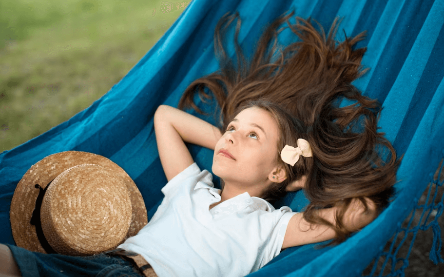 A little girl is lying on a hammock