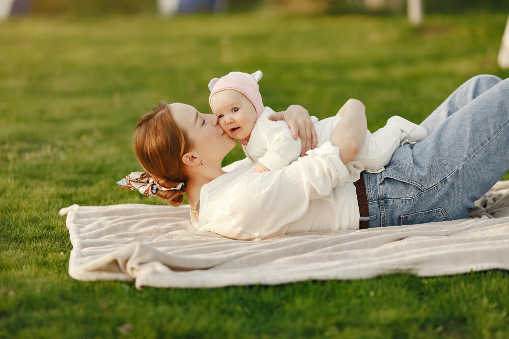 A mother and her baby playing on the grass