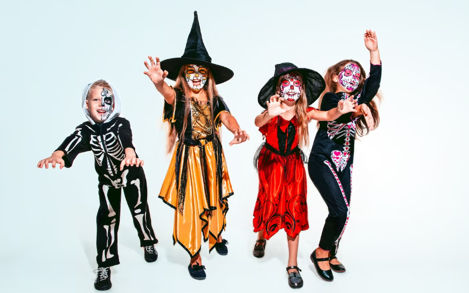 Four children dressed in witch makeup and colorful clothes