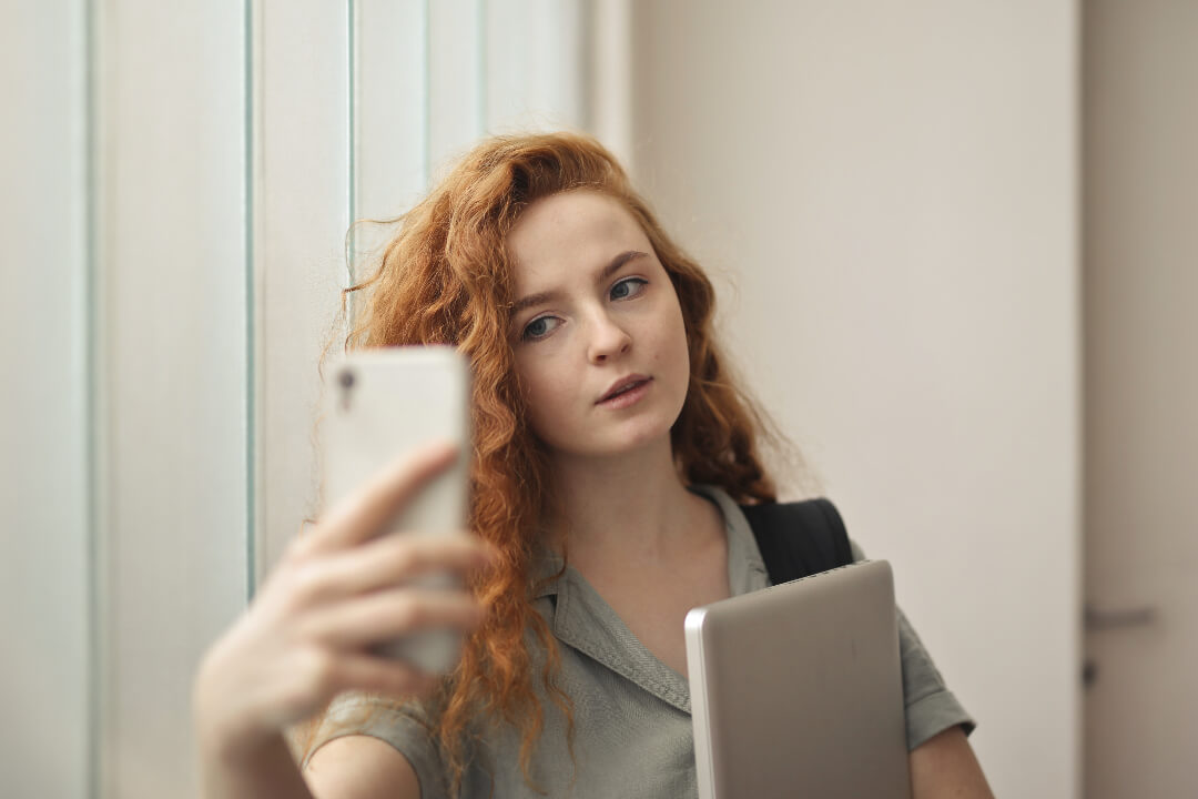 Girl with blonde curly hair taking selfie