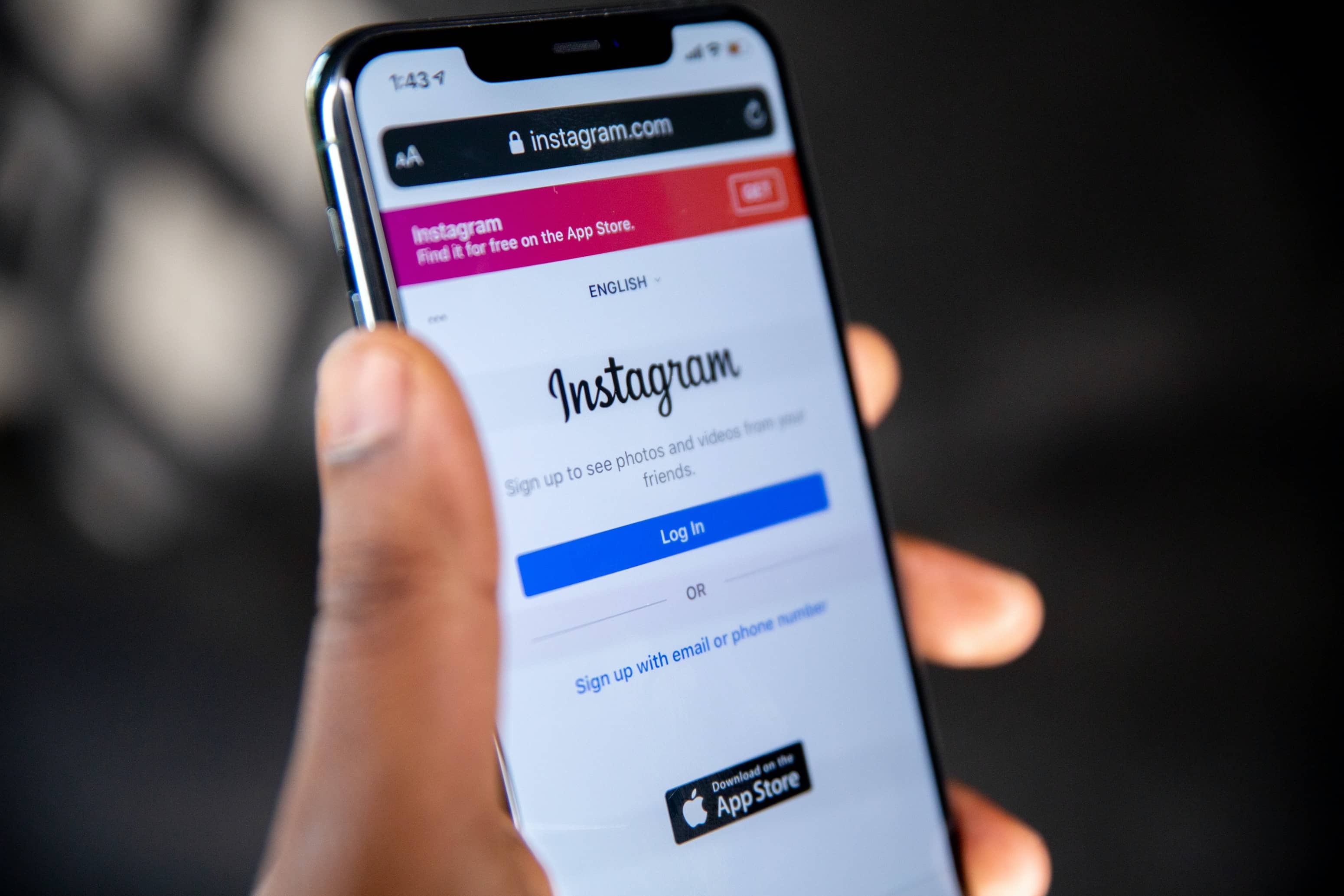 The phone shows Instagram login page
