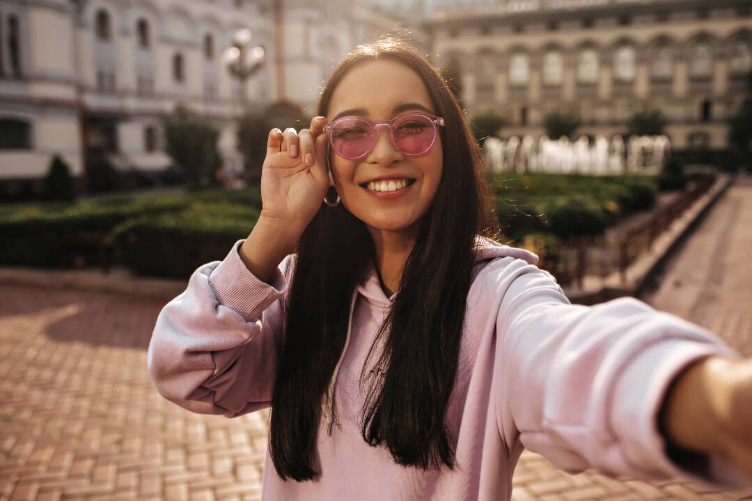 Selfie photo of brunette girl with pink sunglasses