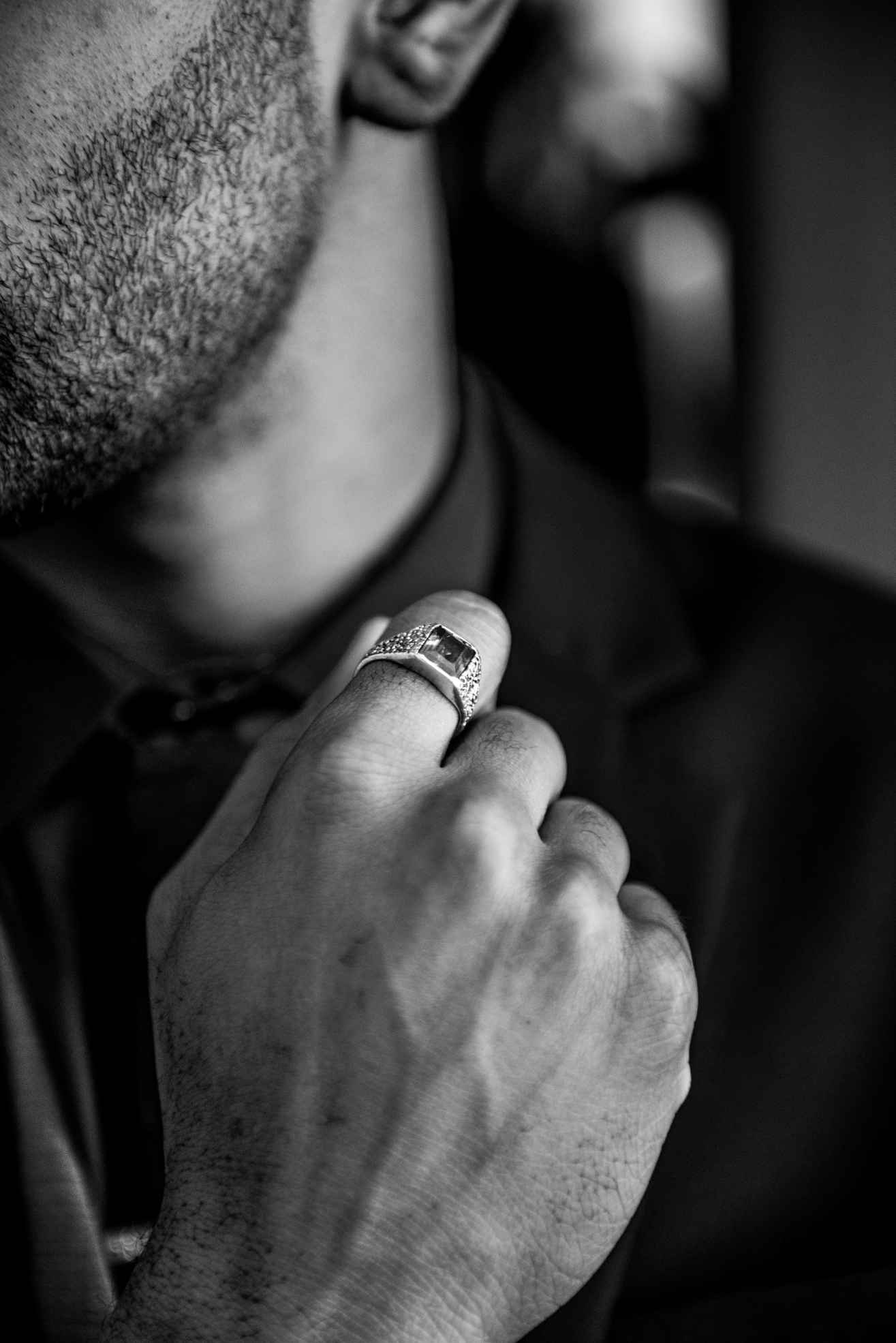 The man wears a ring on his finger