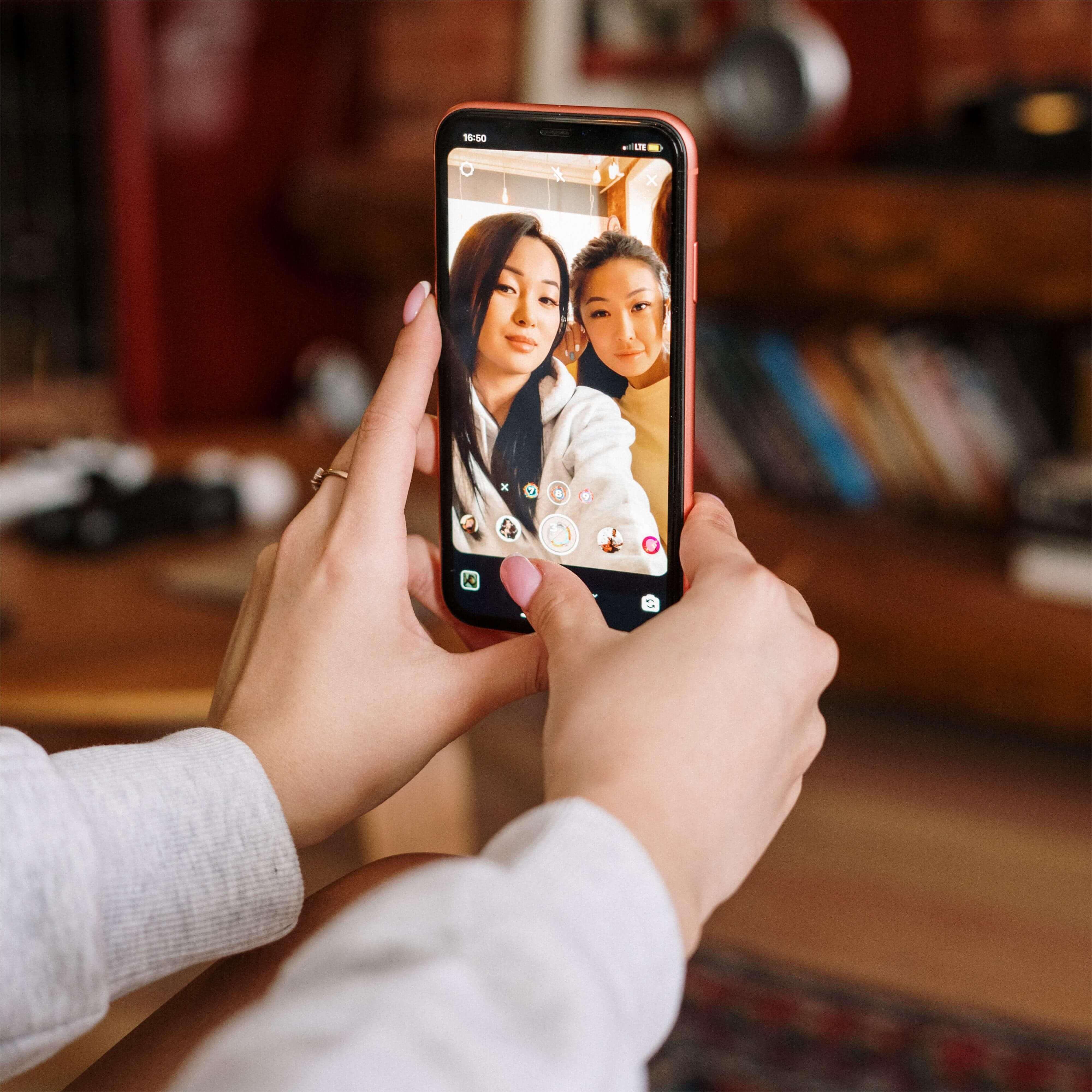 Two girls taking selfies with iphone