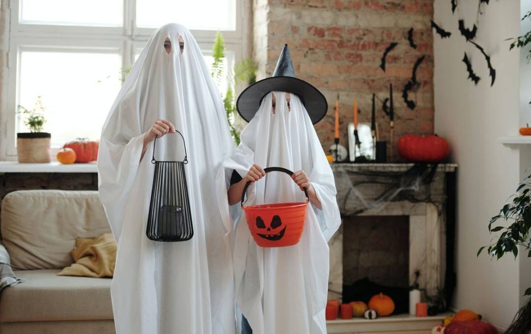 Two people wearing easy and simple Halloween ghost costumes