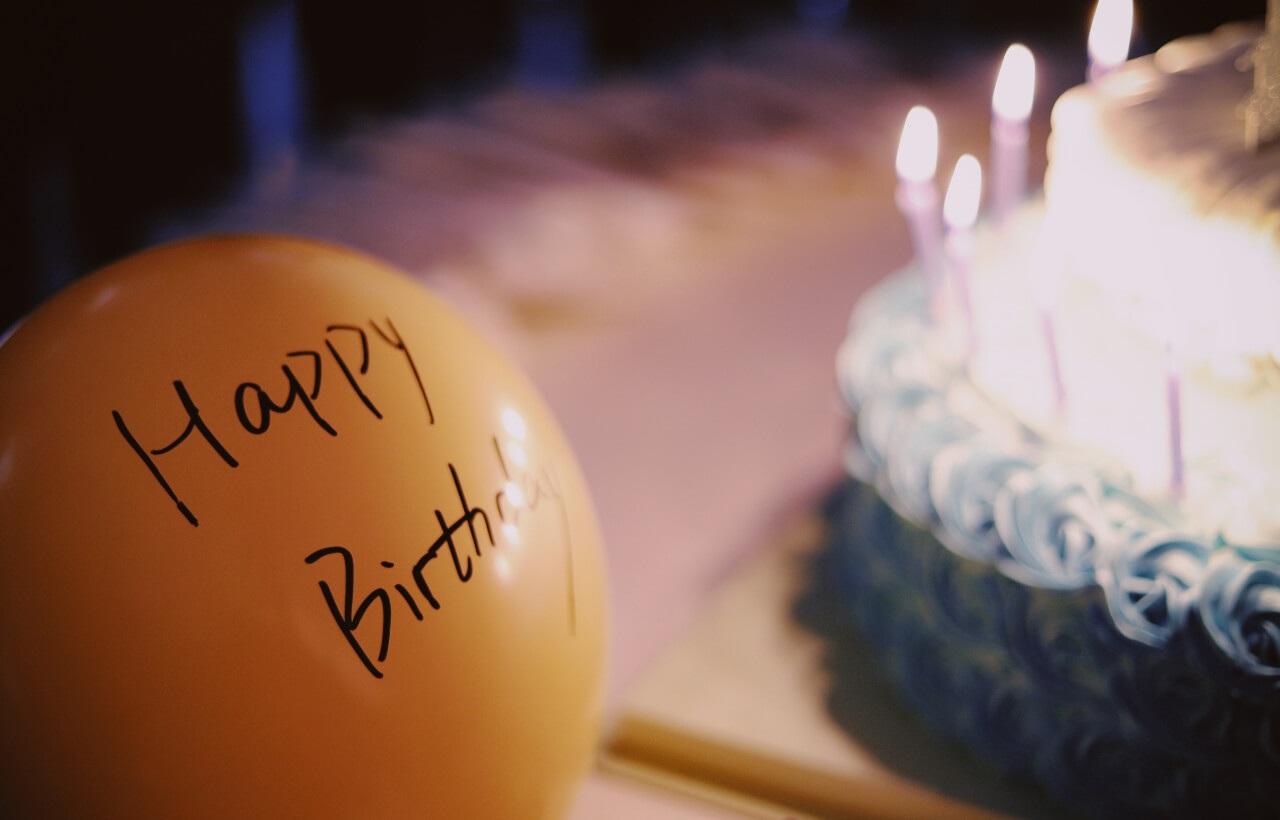 a birthday cake next to the balloon with the words Happy Birthday