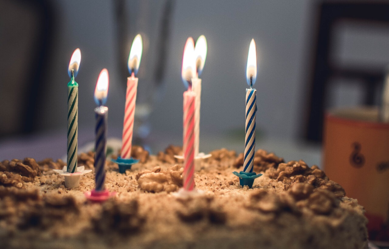 a birthday cake with colorful burning candles