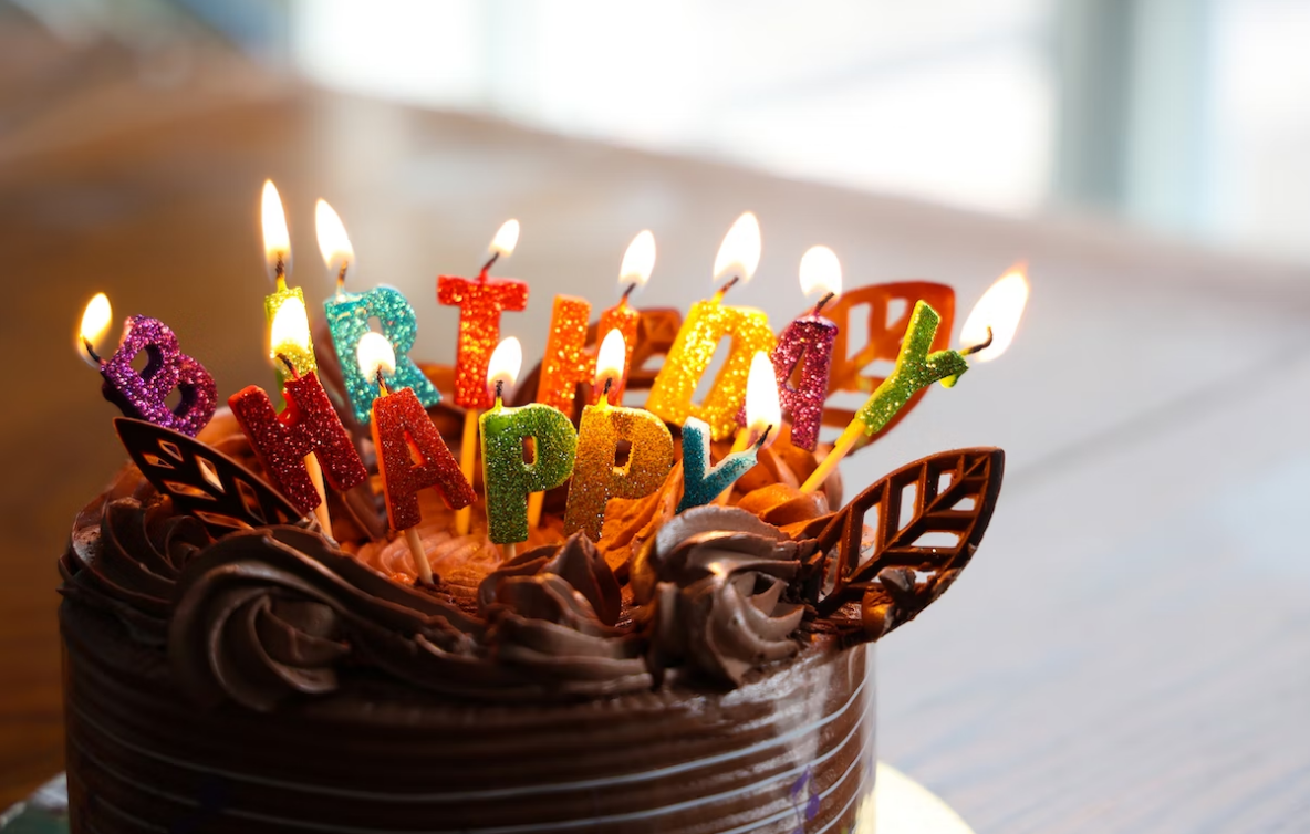 a chocolate birthday cake with colorful candles