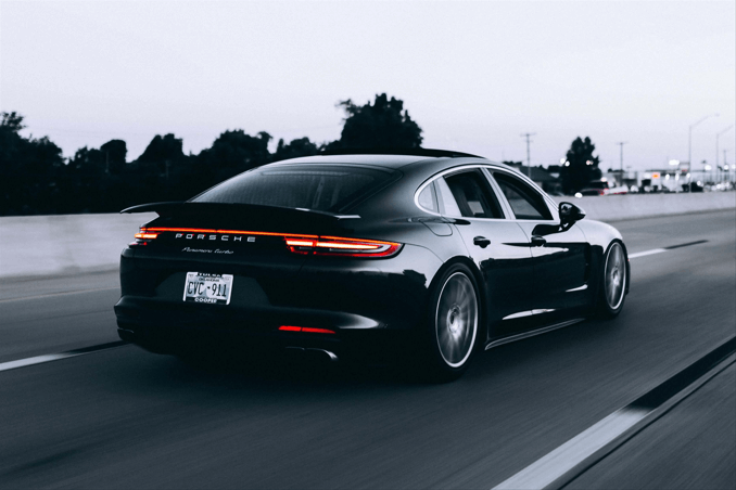 a cool black car driving on road