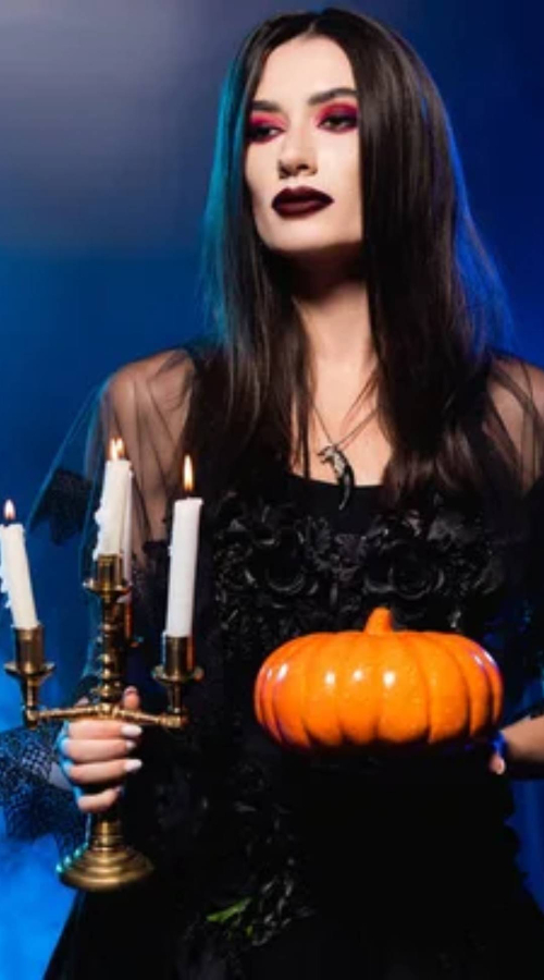 a female vampire holds a pumpkin