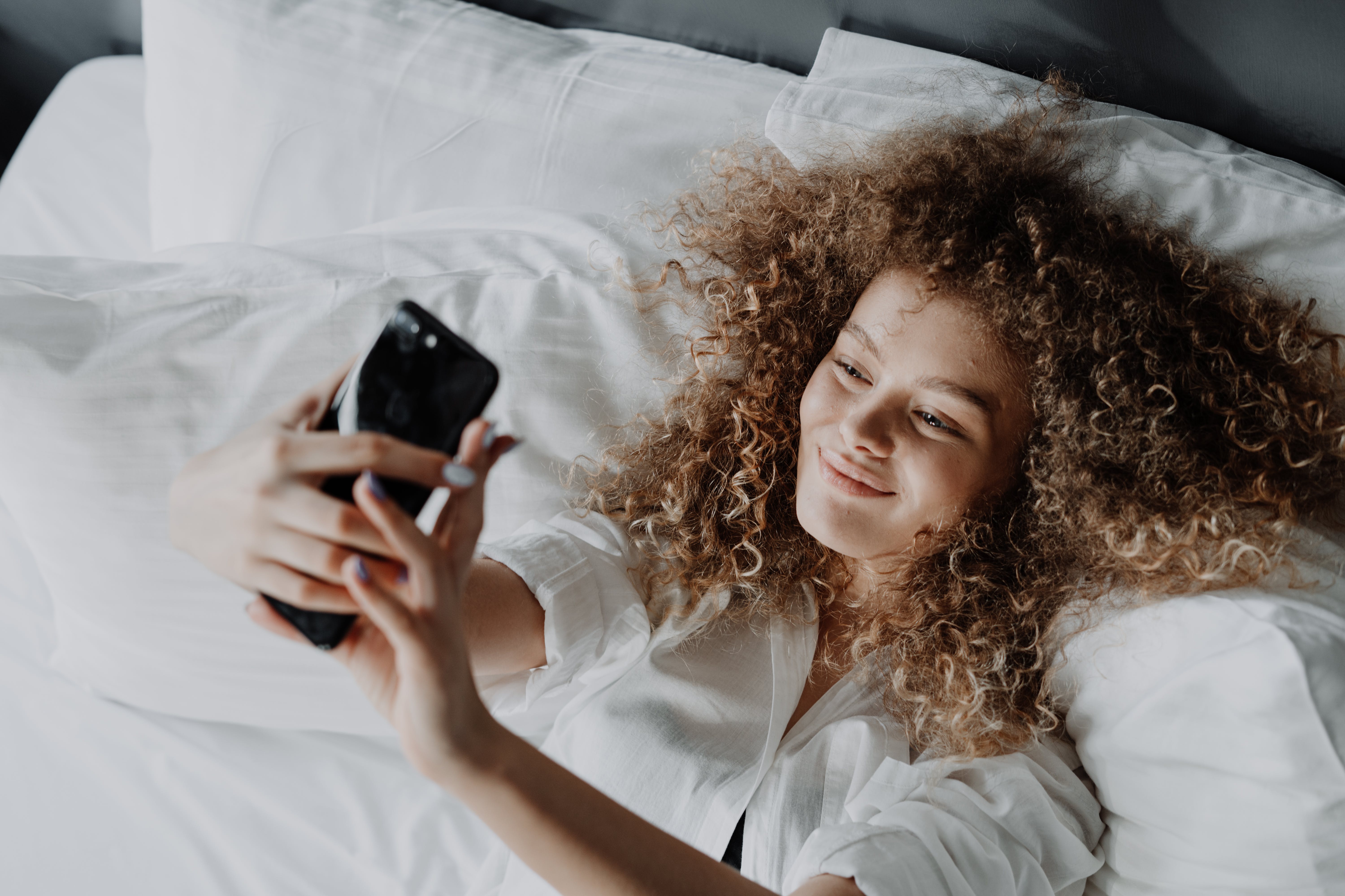 a girl is taking a selfie on the bed