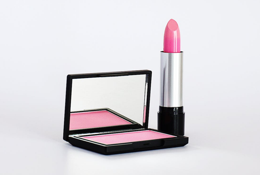 a lipstick and a pink blusher in the white background
