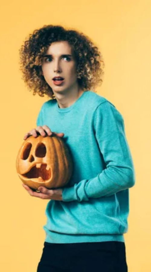 a man holds a pumpkin
