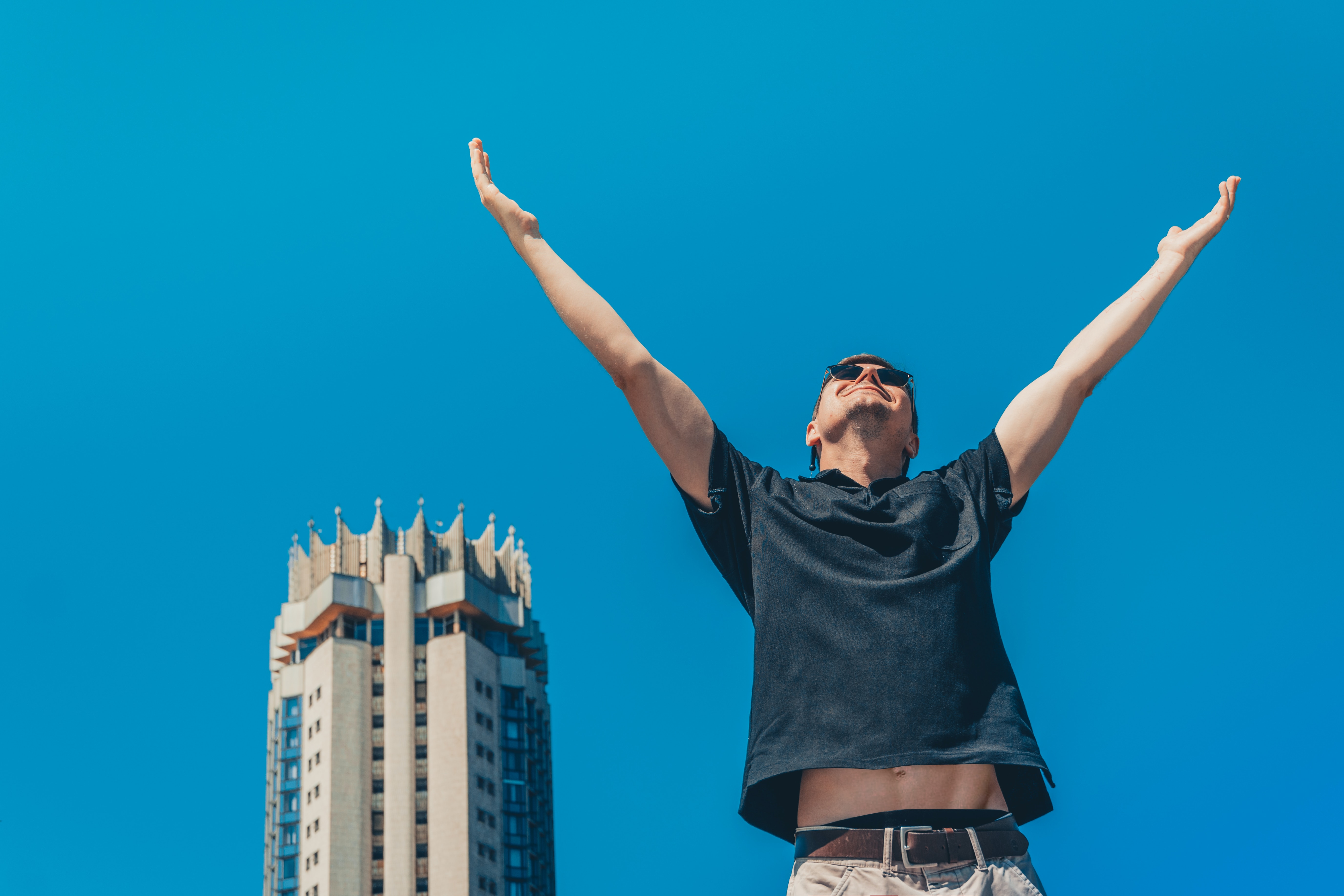 a man throw his hands out with blue background