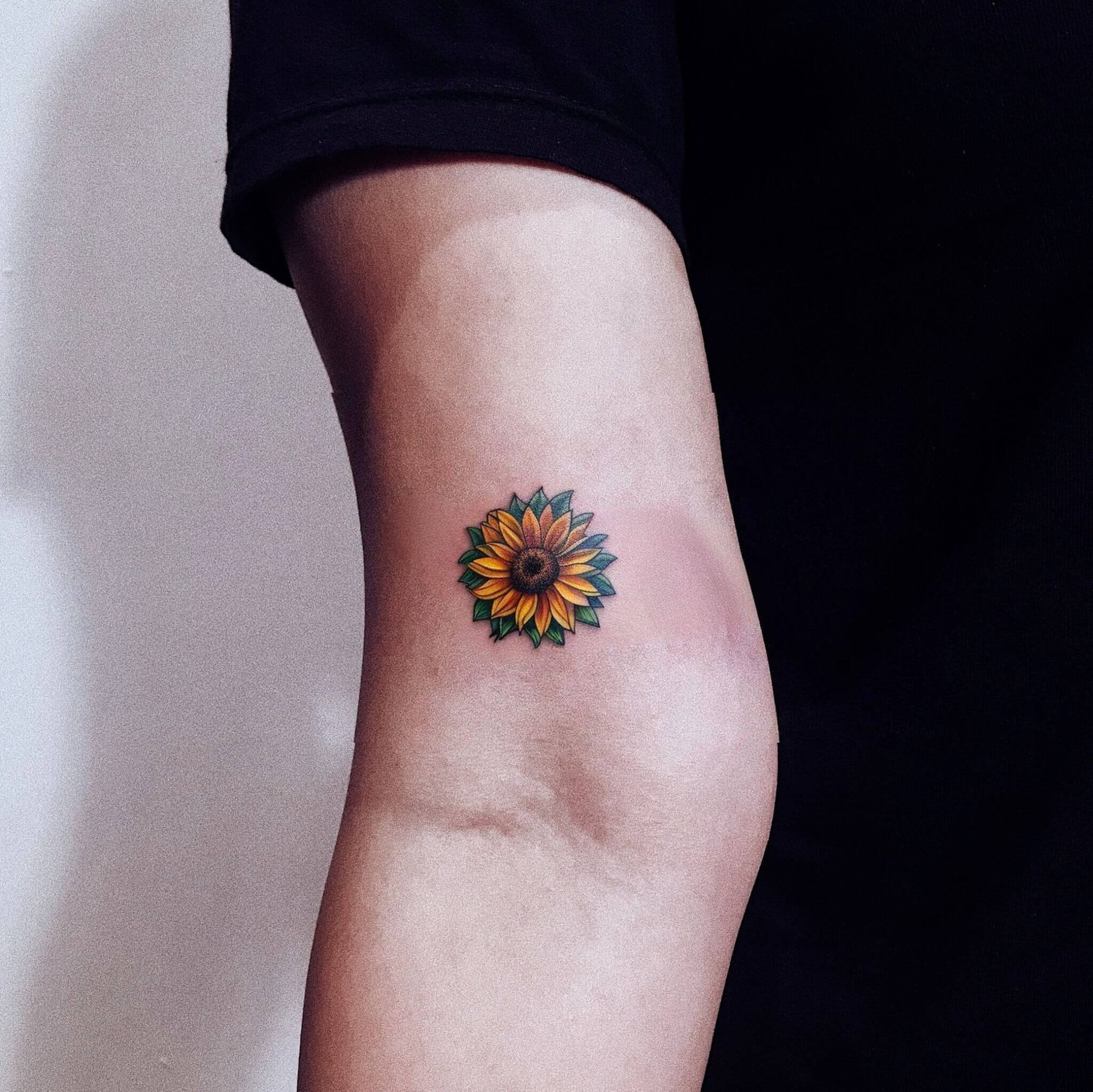 a sunflower tattoo on mans arm