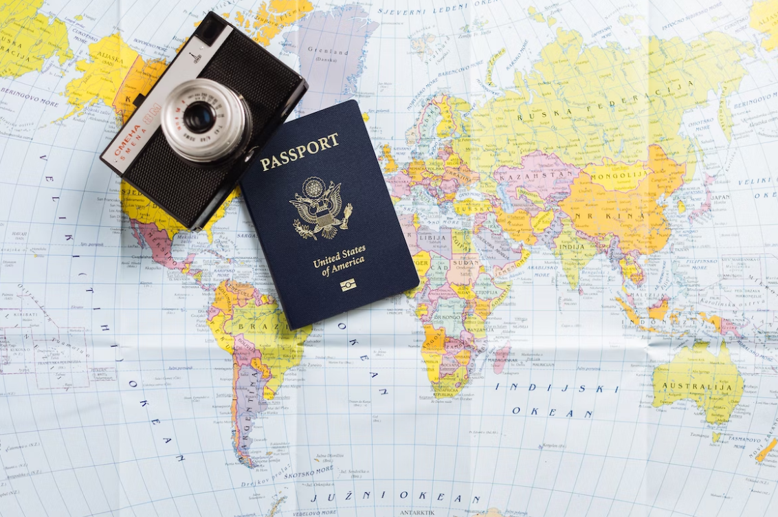 a us passport and a black camera on the world map