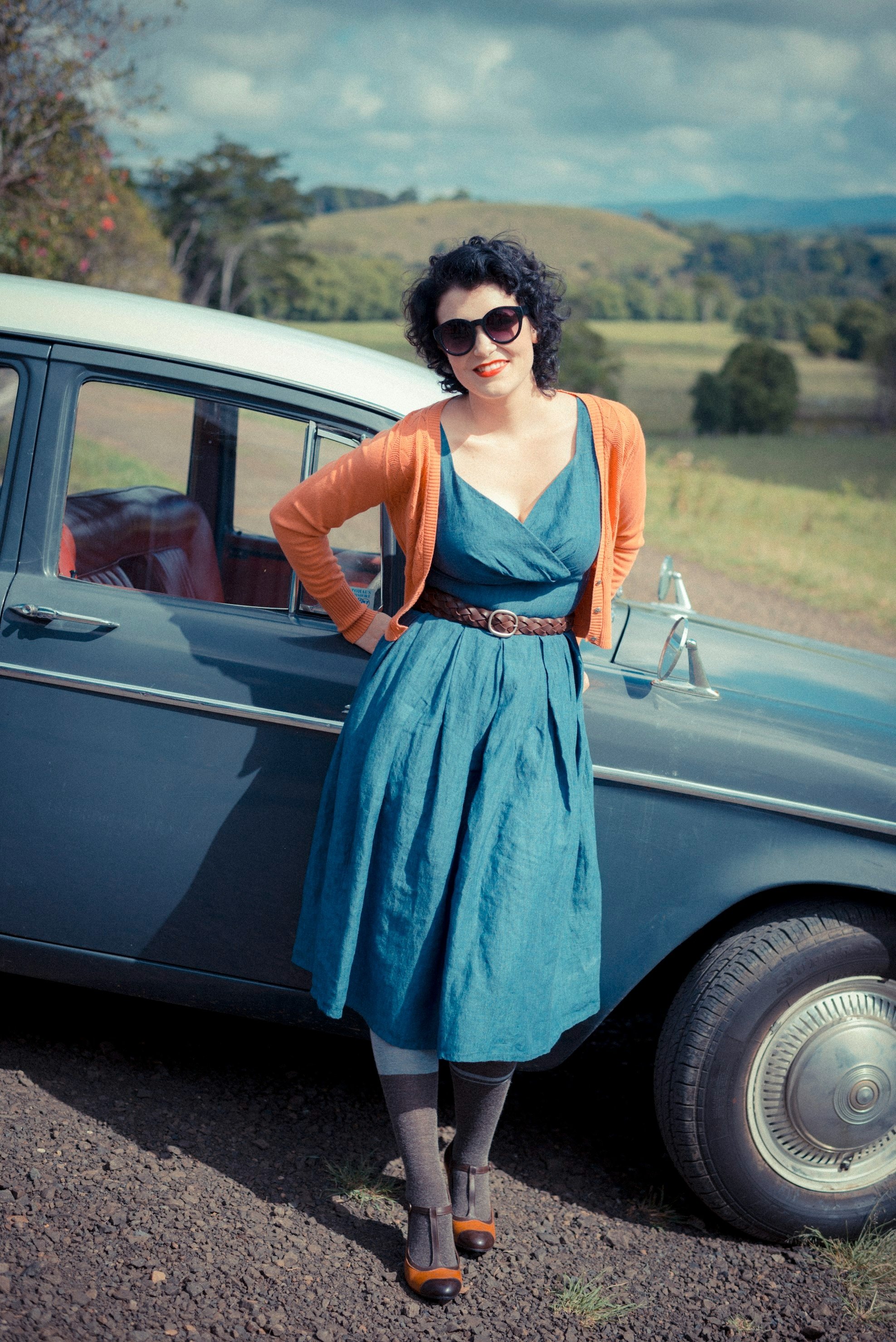 a vintage lady leaning a blue car