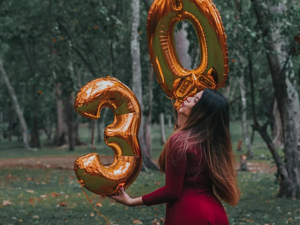 a woman holding the number of 30 in the forests