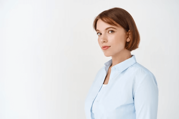 a headshot of a woman with short brown hair, she is wearing a blue shirt and angling her shoulders