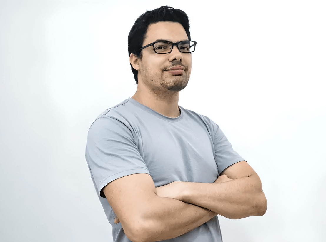 a headshot example of a man who is crossing his arms while standing