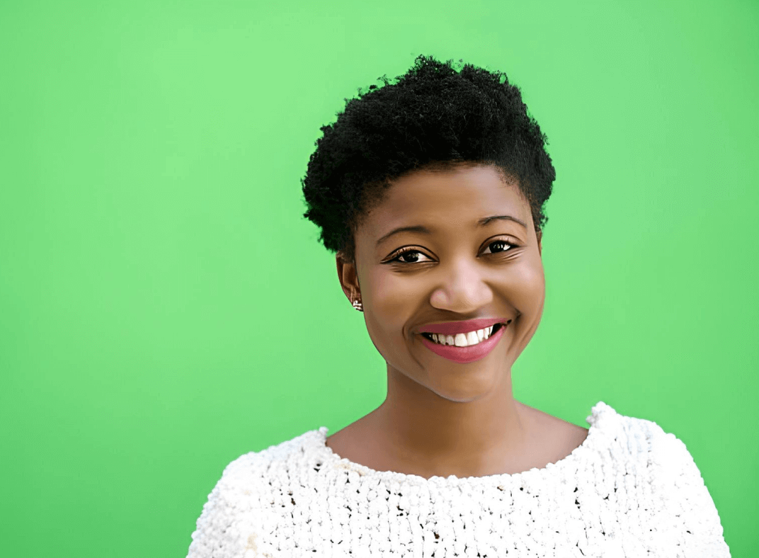 a headshot with a green background showing a woman wearing white sweater is smiling