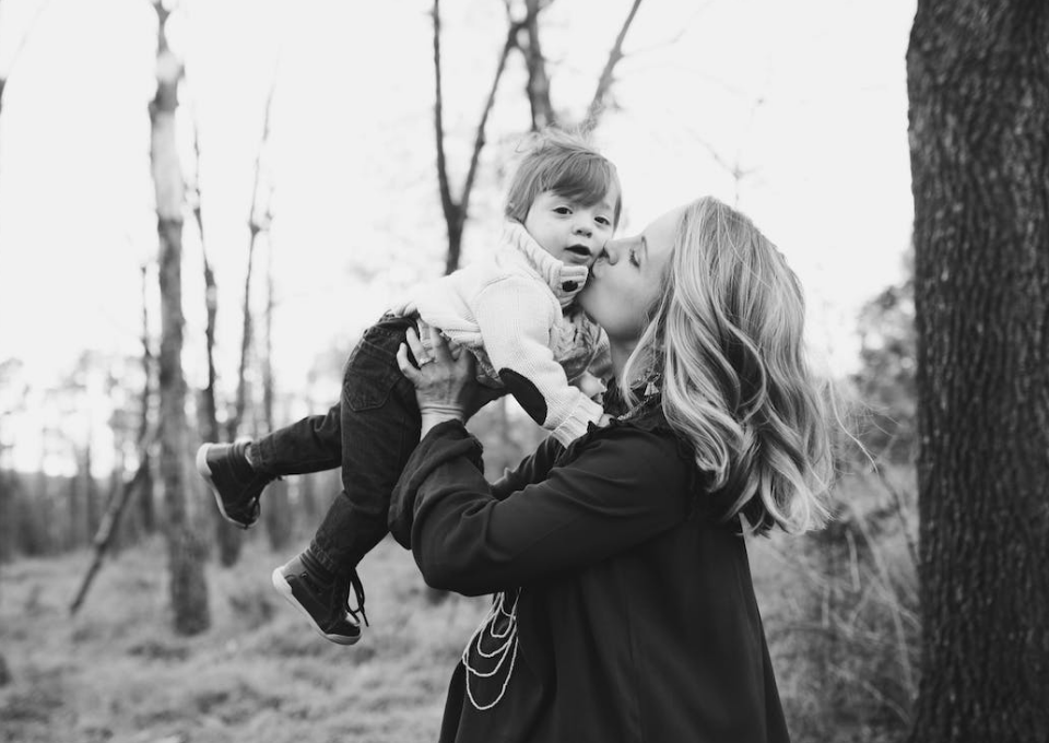 a mom kissing her son photoshoot with black and white effect