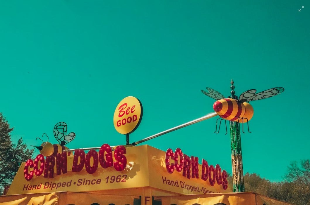 blue sky with yellow signboard of corn dogs