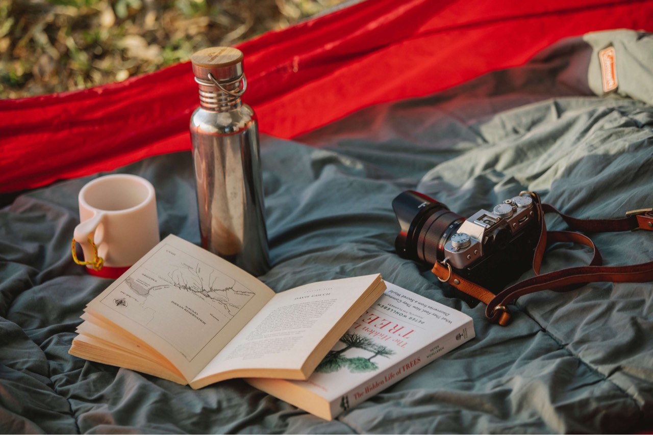 books, mugs and cameras on the mat