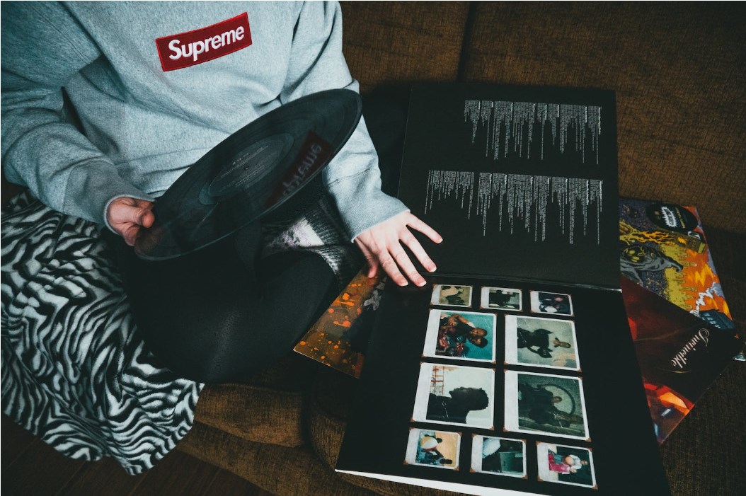 boy hold a vinyl and a collect of album cover images