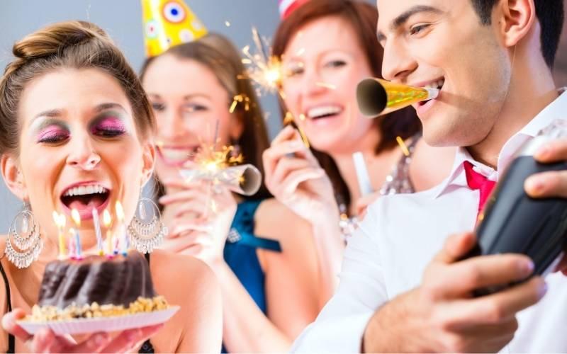 four people celebrating birthday with cake