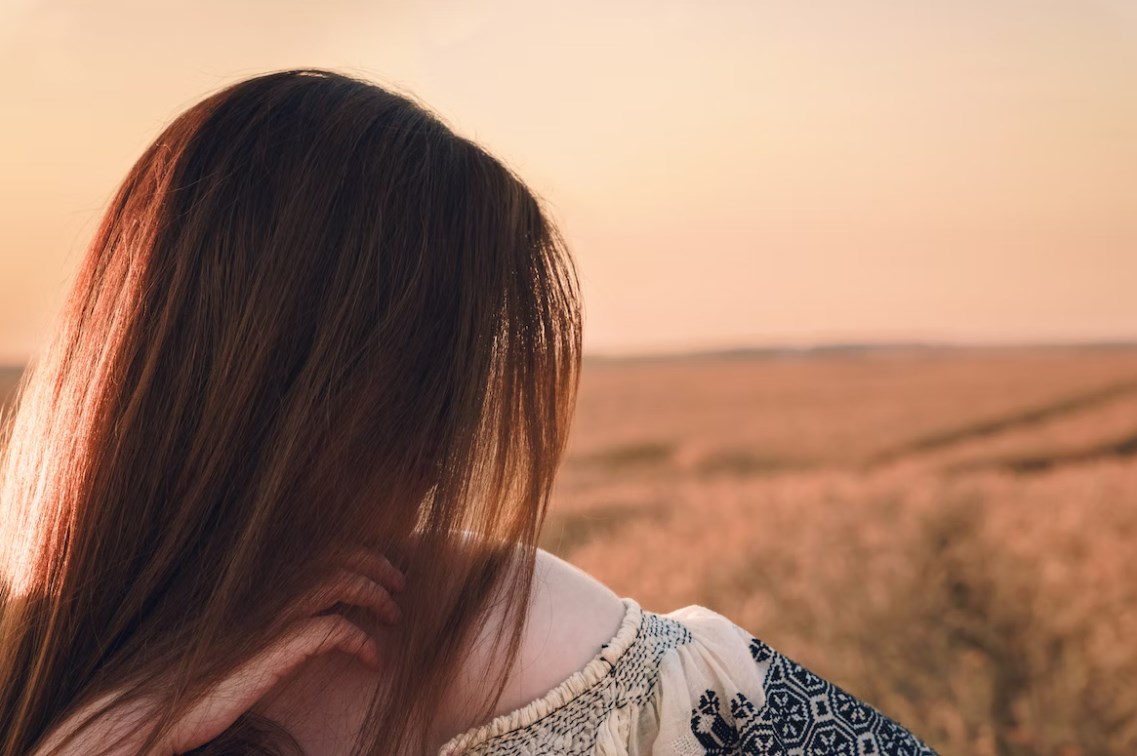 girl side face with grassland background