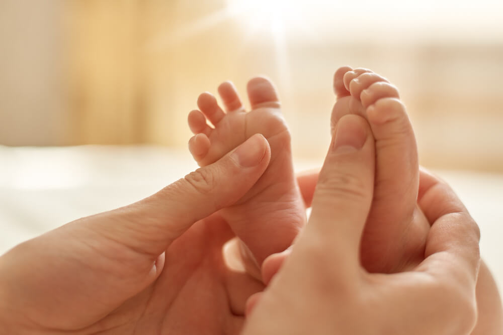 holding newborn baby feet