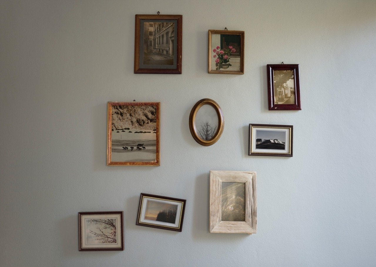many photos on the wall with different frame sizes