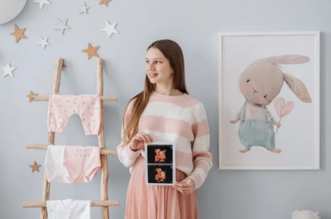 maternity photoshoot at home with baby clothes and a bunny picture