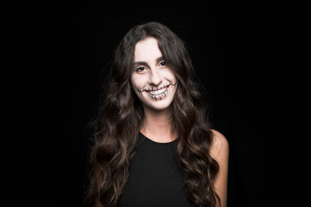 smiling young female with creepy zombie makeup