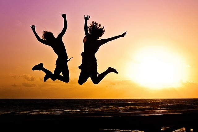 A silhouette shot of two people jumping