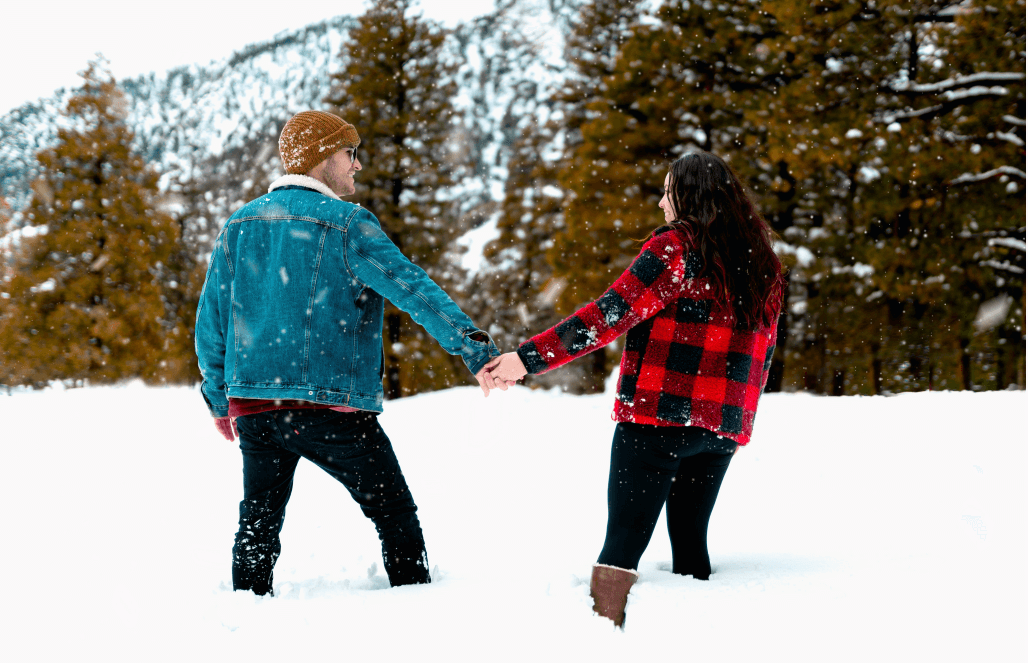 the boy and girl hold hands with their back to the camera