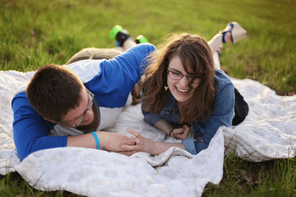 the boy and girl lie on the lawn