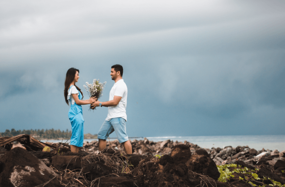 the couple are holding a bunch of flowers