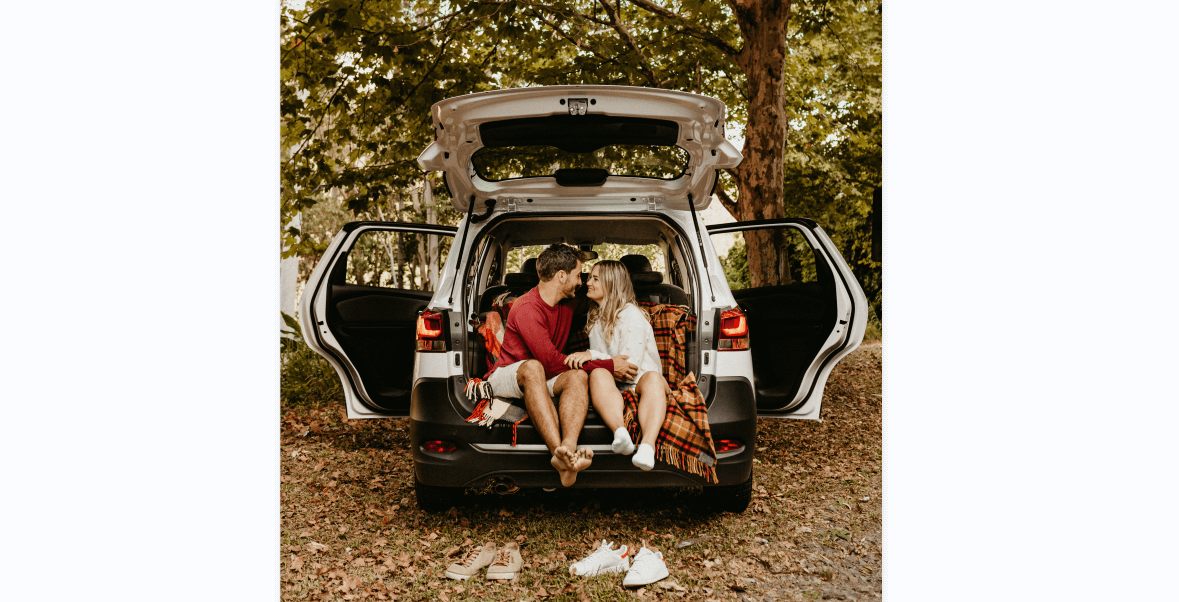 Loving couple sitting on car on road near forest - a Royalty Free Stock  Photo from Photocase