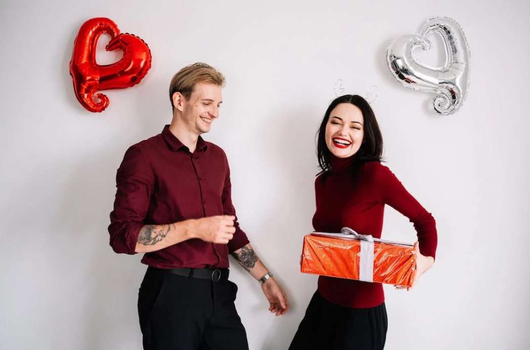 the valentine photoshoot of a couple and two balloons in red and silver
