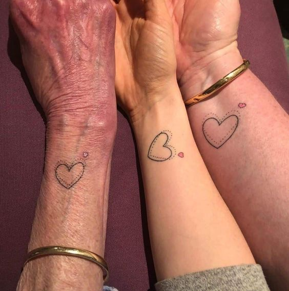 three people with the same family heart tattoo