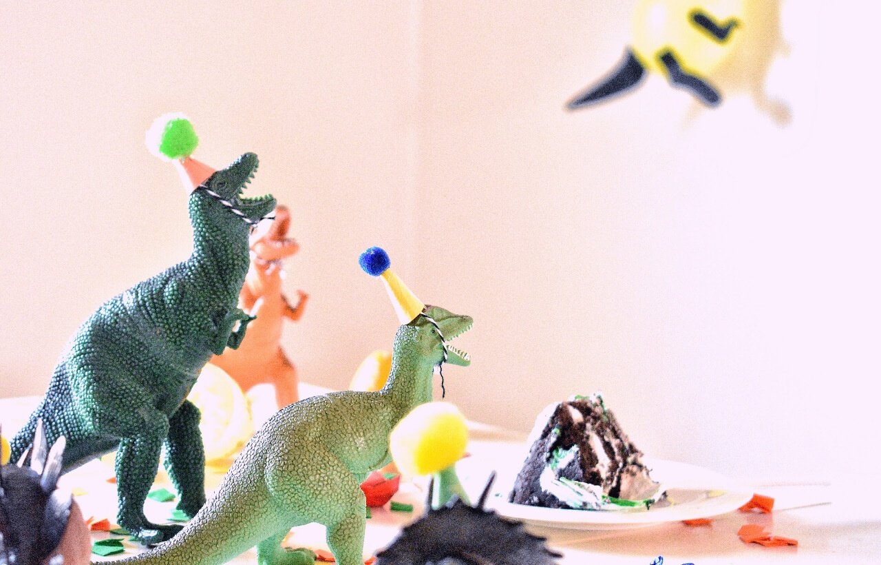 toy dinosaurs wearing birthday hats