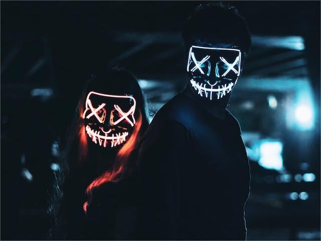 two presons wear evil fluorescent mask