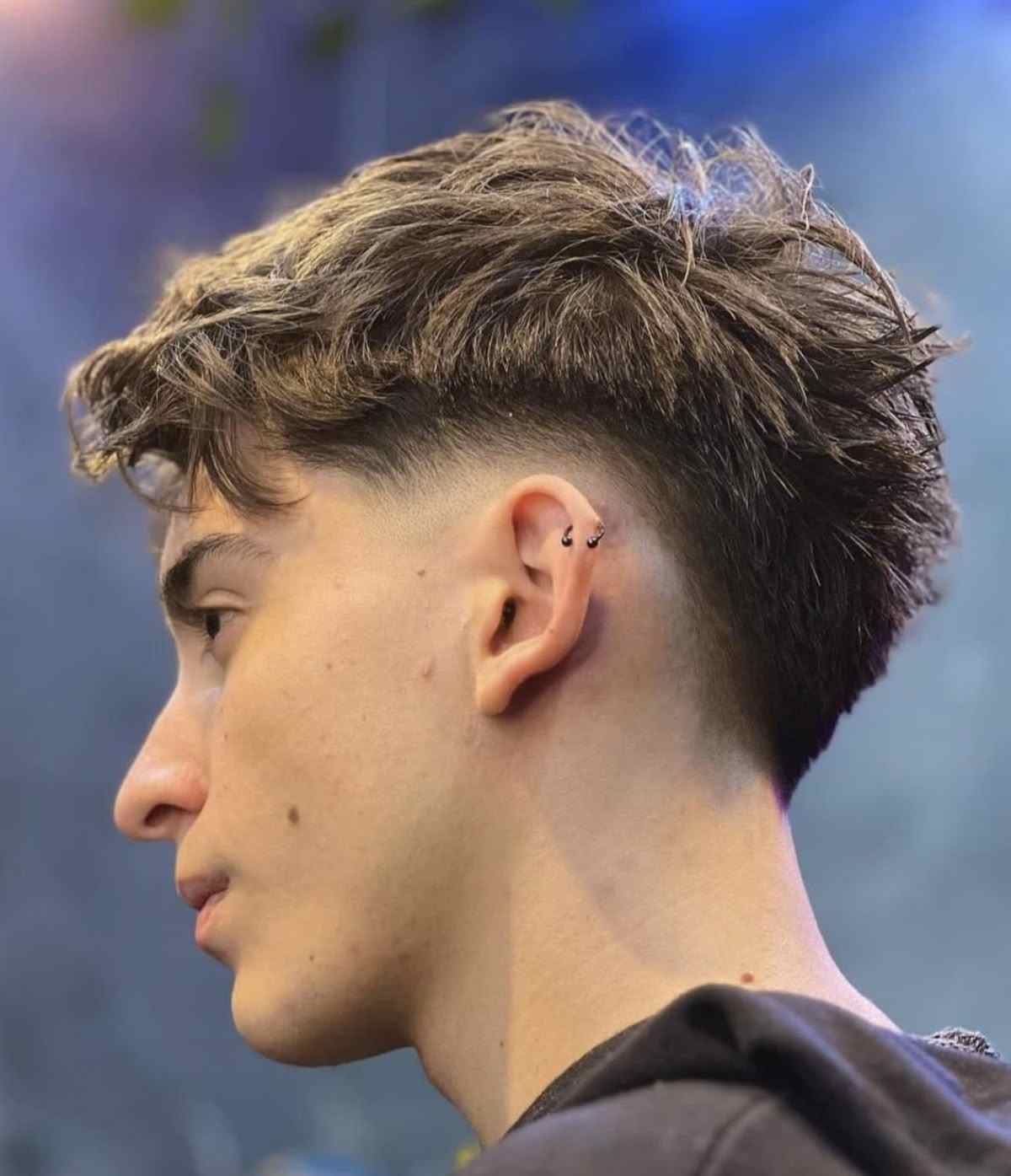 un garçon avec une coupe de cheveux homme Burst fade